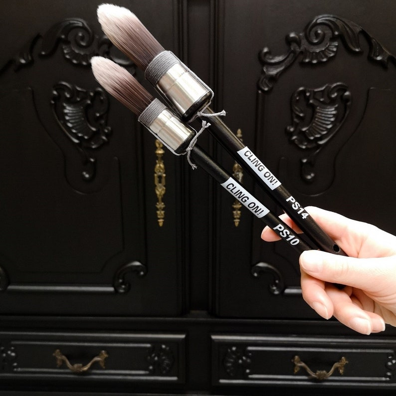 May include: Two black handled paint brushes with gray bristles. The brushes are labeled "CLING ON!" and have the numbers "PS10" and "PS14" printed on them.
