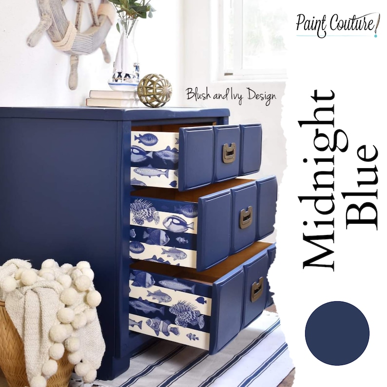 May include: A three-drawer dresser painted in a deep blue color called "Midnight Blue" by Paint Couture. The drawers are decorated with a white and blue fish pattern. The dresser is sitting on a white and blue striped rug.