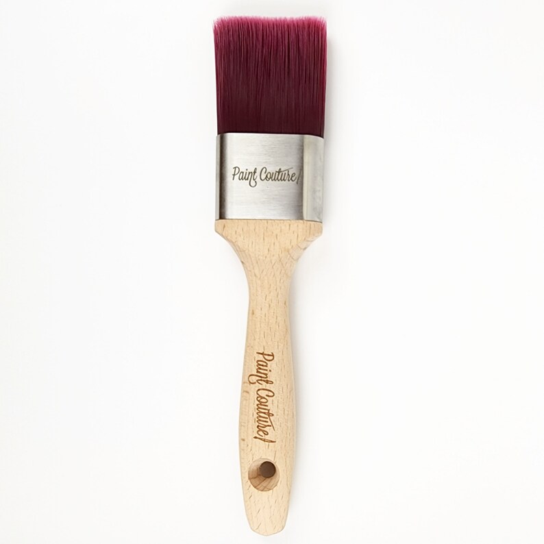 Pu&ograve; includere: Un pennello per dipingere con manico in legno e setole di colore bordeaux. Il pennello &egrave; etichettato "Paint Couture" sulla ghiera metallica e sul manico.