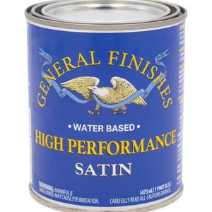 May include: A blue can of General Finishes High Performance Satin water-based paint. The can has a label with an eagle and ribbon design. The label also includes the text "Since 1928" and "Water Based". The can is 473 ml or 1 pint.