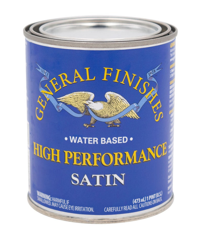 May include: A blue can of General Finishes High Performance Satin water-based paint. The can has a label with an eagle and ribbon design. The label also includes the text "Since 1928" and "Water Based". The can is 473 ml or 1 pint.