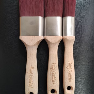 Pu&ograve; includere: Tre pennelli per dipingere con manici in legno e ferrule argentate. I pennelli hanno setole rosse e i manici sono incisi con il testo "Paint Couture".