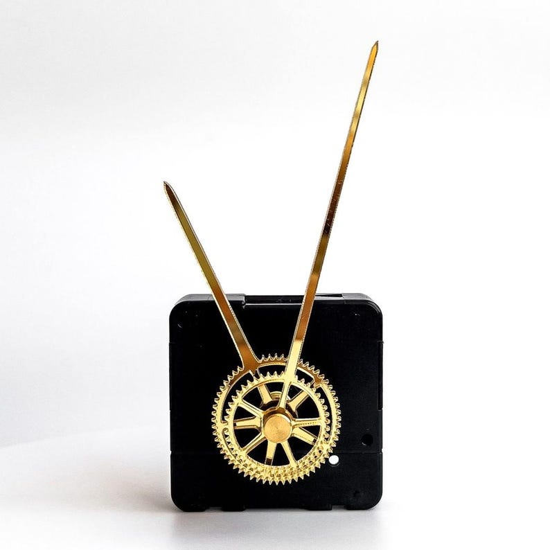 May include: A black clock movement with gold-colored hands and a gear. The hands are long and thin, and the gear is circular with intricate teeth. The clock movement is square-shaped.