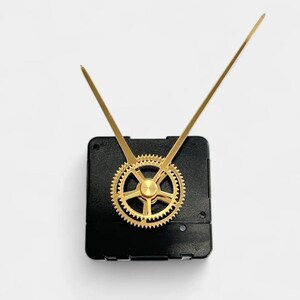 May include: A clock movement with a black square base, gold-colored gear, and gold-colored hands. The hands are long and thin, and the gear is circular with intricate teeth. The clock movement is designed for DIY clock projects.