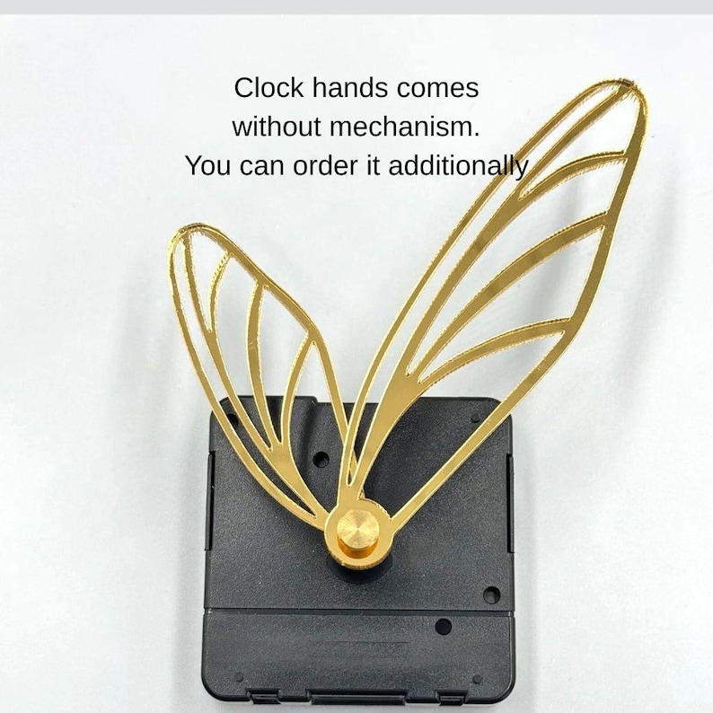 May include: Gold-colored clock hands in a butterfly wing design, attached to a black clock mechanism. The image includes the text: "Clock hands comes without mechanism. You can order it additionally."