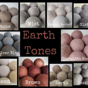 May include: A collection of 10 wool dryer balls in various earth tones, including Stone, Mist, Natural, Un-dyed, Slate, Silver Blue, Chocolate Rose, Sand, Brown, Earth, and Heather. The dryer balls are arranged in a grid pattern with the text "Earth Tones" in the center.