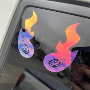May include: Two iridescent flame decals with a black outline. The flames are in shades of yellow, orange, red, blue, and purple.
