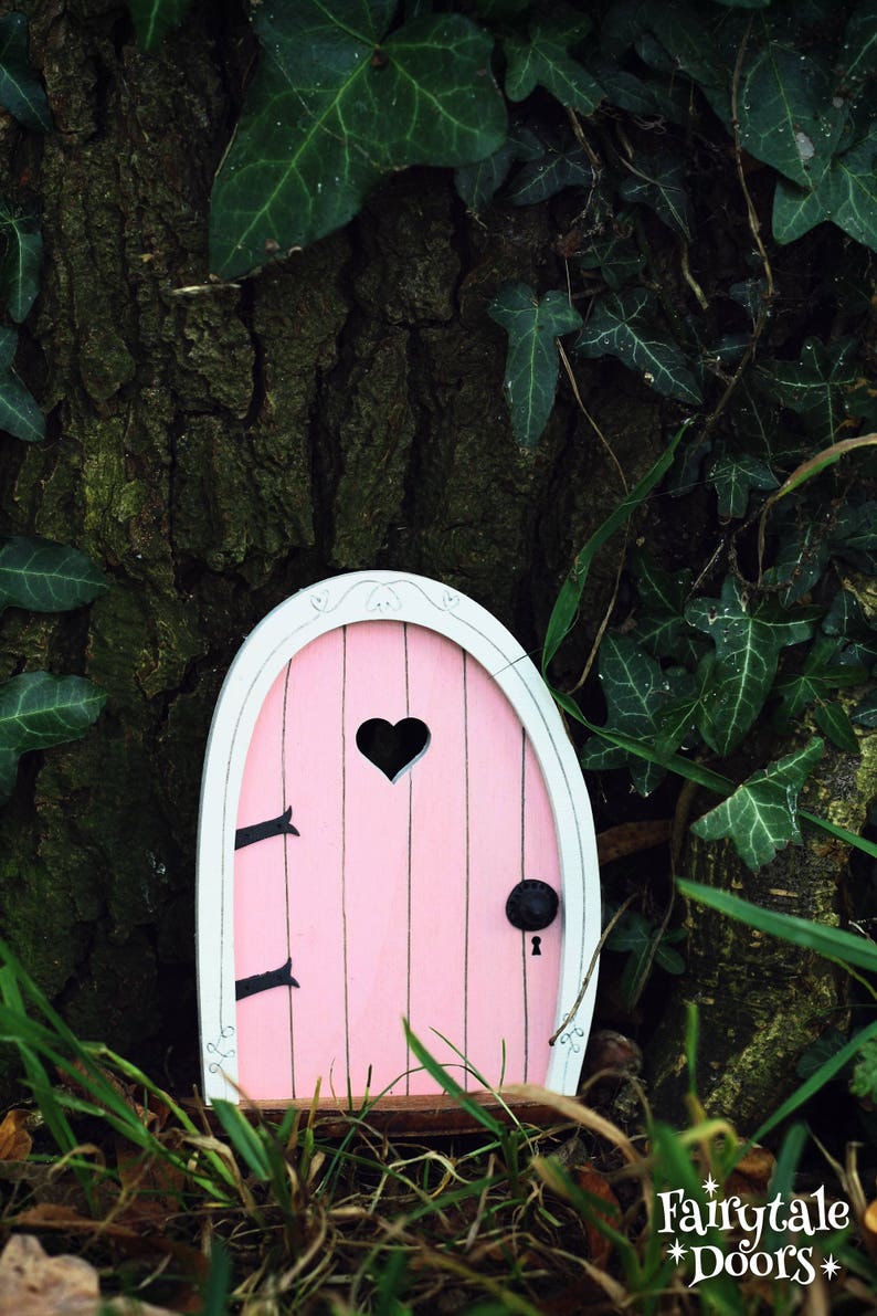a pink fairy door with a heart shaped window