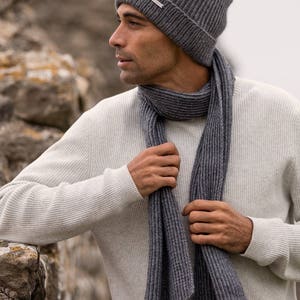 May include: A gray ribbed knit beanie and matching scarf. The beanie has a small silver tag with the brand name on it.