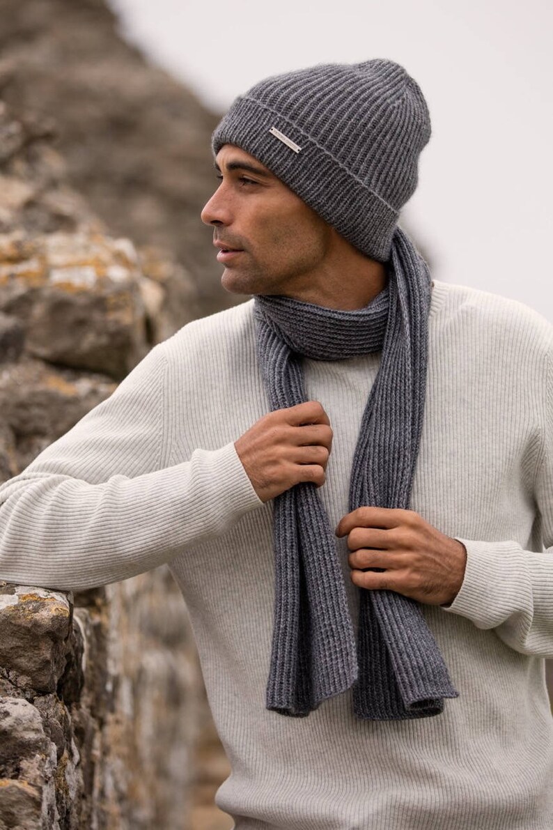 May include: A gray ribbed knit beanie and matching scarf. The beanie has a small silver tag with the brand name on it.