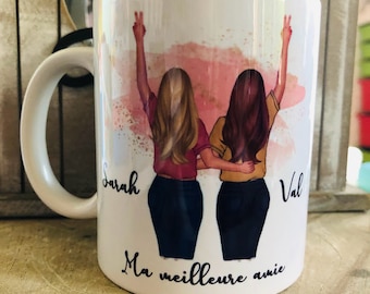 May include: White ceramic mug with a watercolor design of two women with their arms raised in the air. The women are wearing jeans and shirts. The text "Sarah" and "Val" are written on the mug, along with the phrase "Ma meilleure amie".