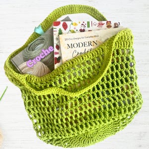 May include: A lime green crocheted tote bag filled with books and yarn. The bag has a large handle and an open weave design. The books include "20 Chic Designs for Everyday Wear" and "Modern Crochet".