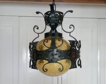 Gran lámpara colgante de hierro forjado negro vintage con vidrio amarillo en sala de estilo colonial gótico o español o pasillo de los años 50 Lámpara vintage con bombilla amarilla