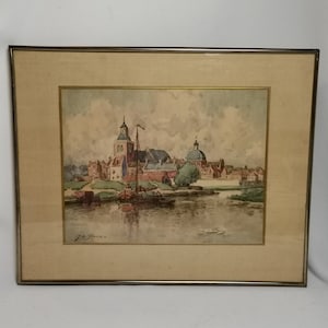 Antica vista del villaggio ad acquerello o paesaggio urbano con edifici e chiesa sull'acqua Leerdam J le Blanc in cornice anni '20 Pittura villaggio città