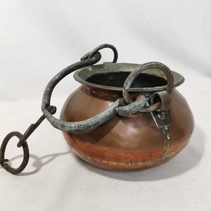 Pode incluir: Uma caneca de cerâmica branca com uma alça preta e o texto "But First, Coffee" em negrito preto. A caneca está sobre um fundo neutro, destacando seu design simples.