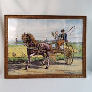May include: A framed tile painting depicting a horse-drawn carriage with two people riding in it. The carriage is traveling along a dirt road with a windmill in the background. The painting is done in a realistic style with vibrant colors.