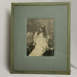 Antique portrait photo of young lady in frame with stand 1900s Antique girl portrait | Sepia photo of girl hanging or standing in frame
