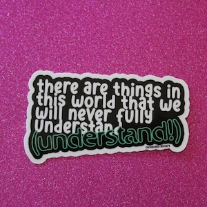 May include: A black and white sticker with the text "there are things in this world that we will never fully understand!" in a white outline with a green outline around the word "understand!" The sticker is on a pink glitter background.