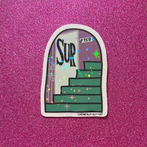 May include: A sticker with a glittery, iridescent finish featuring a cartoon illustration of a doorway with stairs leading up to a room with the word "SUR" on the wall. The door has the number "8759" on it. The sticker has the text "CHRONICALLY GLITTERY" at the bottom.