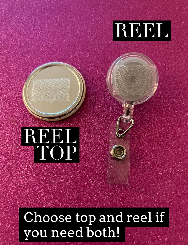 May include: Two silver badge reels, one with a clear plastic cover and the other with a silver top. The reel with the clear plastic cover has the word "REEL" printed on it. The reel with the silver top has the words "REEL TOP" printed on it. Choose top and reel if you need both!