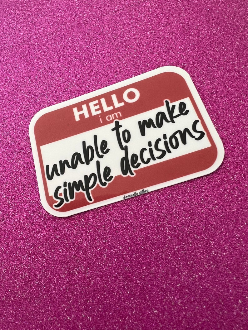 May include: A white sticker with a red border and rounded corners. The sticker says "HELLO I AM unable to make simple decisions" in black text.