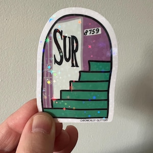 May include: A holographic sticker featuring a green staircase leading to a door with the word "SUR" and the number "8759" on it. The sticker has a glittery finish and says "Chronically Glittery" at the bottom.