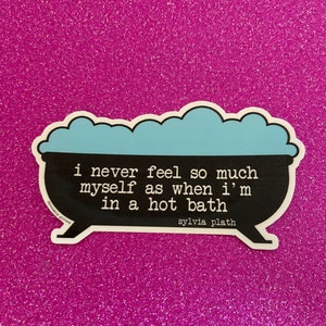 May include: A black and white sticker with a quote by Sylvia Plath that reads "i never feel so much myself as when i'm in a hot bath". The sticker is shaped like a bathtub with blue foam on top.