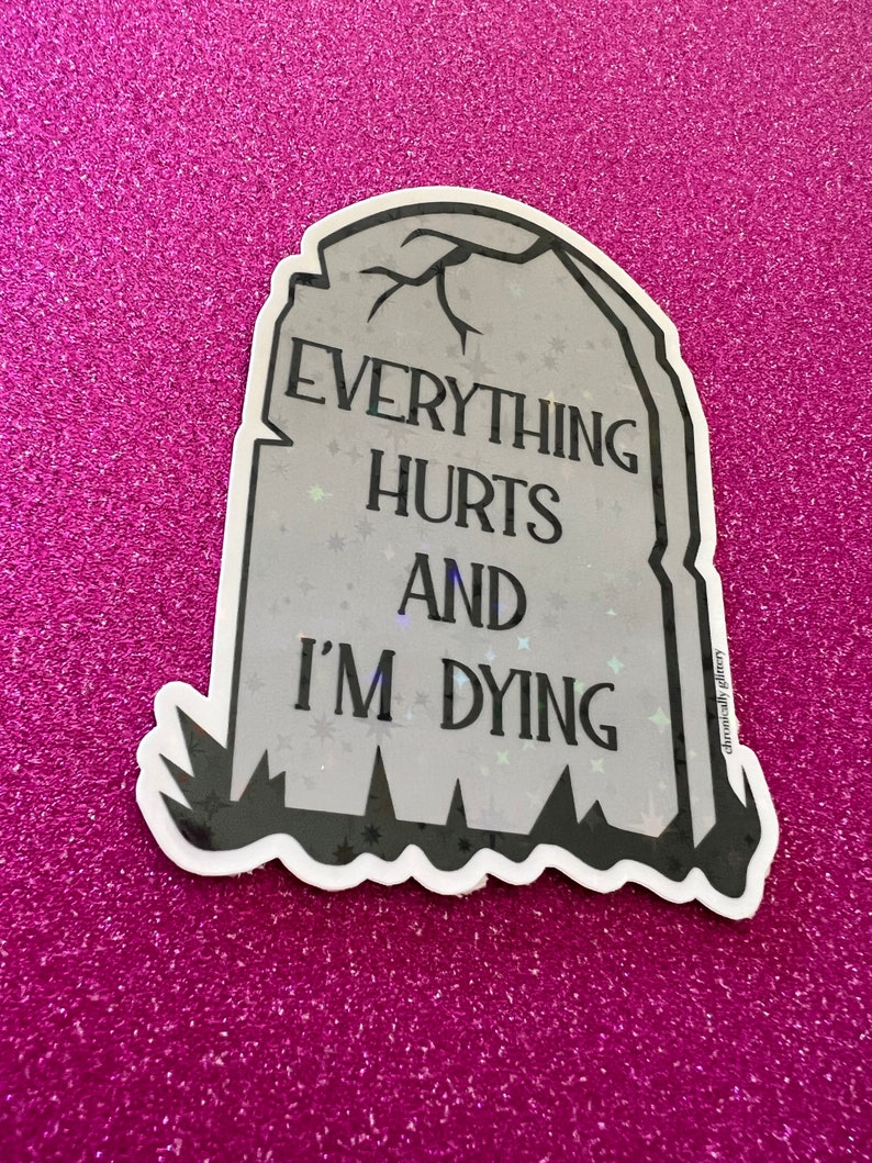 May include: A gray tombstone sticker with the text "Everything Hurts And I'm Dying" in black lettering. The sticker has a glittery finish and a black outline.