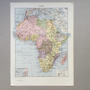 Può includere: Una mappa vintage dell'Africa del 1900, che mostra le divisioni politiche del continente. La mappa è stampata in bianco e nero con bordi colorati per ogni paese. La mappa è intitolata "Afrique" e include una chiave con i nomi dei paesi.