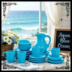 May include: A turquoise ceramic tableware set, including cups, saucers, bowls, and a pitcher, is arranged on a table. The set is complemented by a floral arrangement and a chalkboard sign that reads "Aqua Blue Ocean".