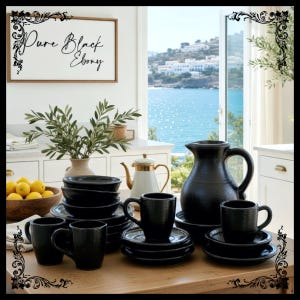 May include: A collection of black ceramic tableware, including mugs, saucers, bowls, and a pitcher, arranged on a wooden table. The text "Pure Black Ebony" is displayed on a framed sign in the background. The scene is set in a bright kitchen with a view of the sea.