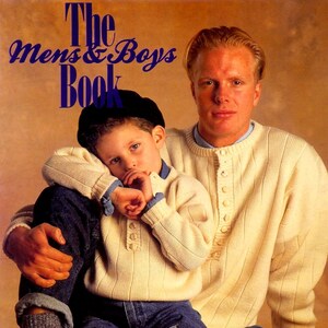 May include: The cover of "The Mens & Boys Book" features a father and son. Both are wearing cream-colored sweaters with button details and blue jeans. The son wears a black cap. The magazine title is in blue, with red text at the bottom.