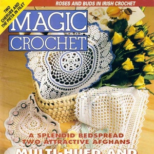 Puede incluir: Una portada de revista para Magic Crochet con un encaje de ganchillo blanco con borde azul, una cesta de rosas amarillas y el texto "Crochet multi-tonal y dimensional".