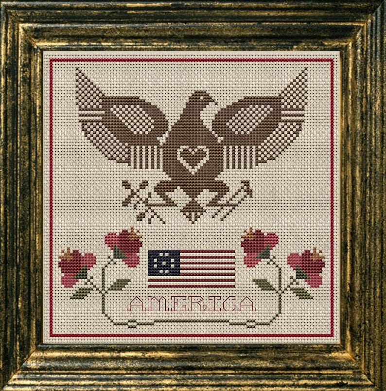 May include: A cross-stitch pattern featuring an American bald eagle with a heart in its chest, a flag with 13 stars, and the word "AMERICA" below. The eagle is brown and the flag is red, white, and blue.