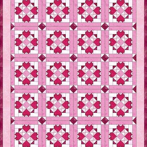 K&ouml;nnte beinhalten: Ein rosa und wei&szlig;es Quilt mit einem sich wiederholenden Muster aus Herzen und Quadraten. Das Quilt hat einen Rand mit einem floralen Design. Die Herzen sind in Rosa- und Rott&ouml;nen gehalten, und die Quadrate sind wei&szlig;.