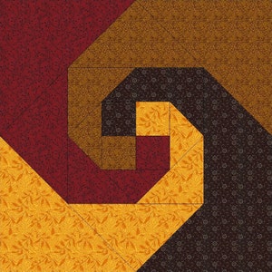 May include: A square quilt block featuring a spiral pattern constructed from fabric pieces in shades of deep red, golden yellow, brown, and dark chocolate. Each section displays a subtle, repeating floral or leaf print across the surface.