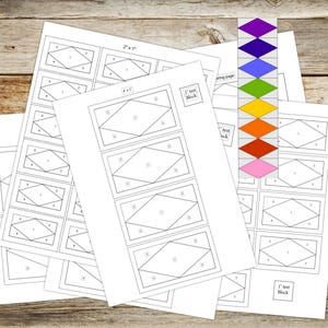 May include: Several white paper sheets featuring geometric designs and the text "2" x 1" and "1" test block". A colour guide with diamond shapes in various colours is also present. The papers are arranged on a wooden surface.