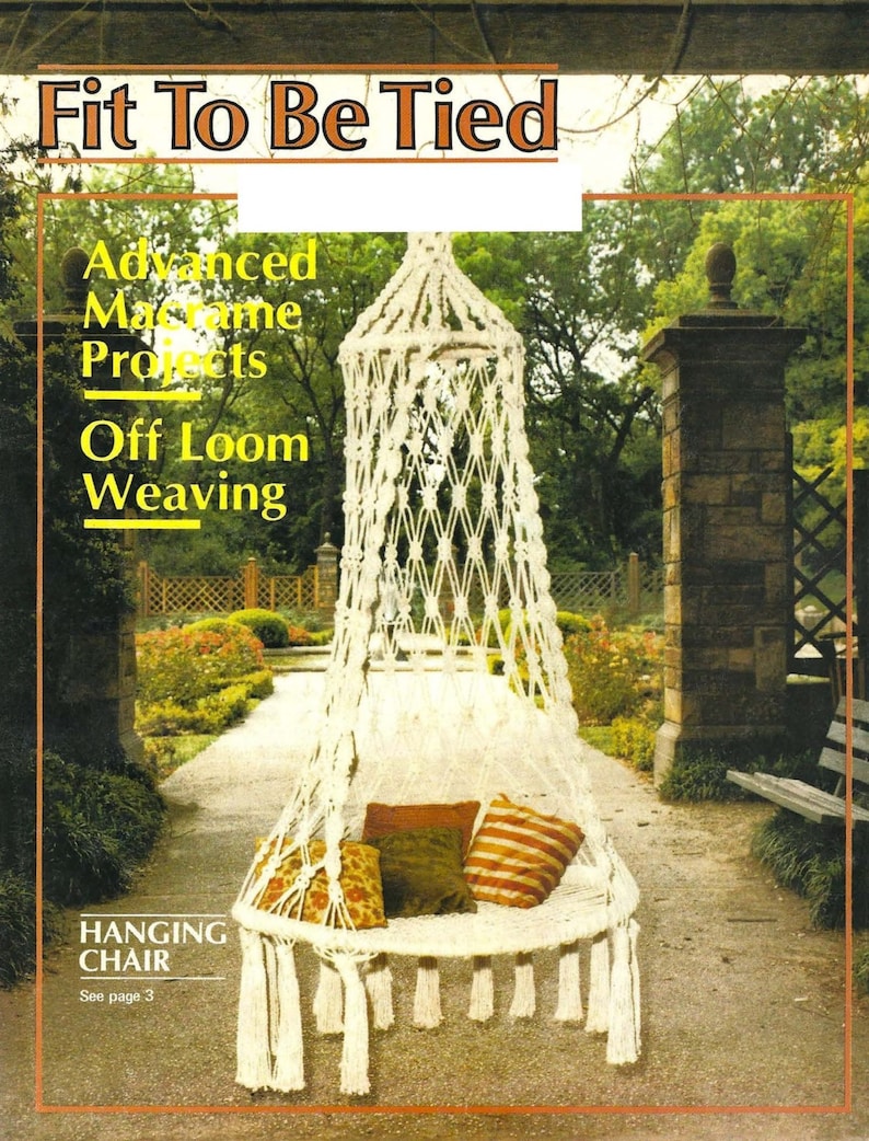 May include: A white macrame hanging chair with fringe,  cushions, and the text "Fit To Be Tied" above it.  The chair is in a garden setting with green plants and a stone walkway.