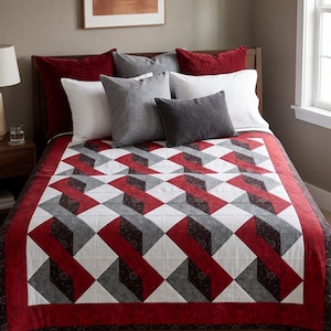 May include: A quilt featuring a geometric pattern of interlocking shapes in shades of red, white, dark grey, and black. The design consists of repeating squares and diamond-like forms arranged in a grid, finished with a solid red border.
