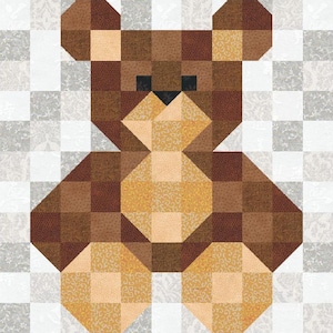 May include: A square quilt block featuring a pixelated teddy bear design constructed from various shades of brown and tan fabric squares. The bear has dark brown eyes and a nose, set against a background of light gray and white patterned squares.