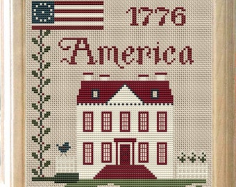 May include: Cross-stitch pattern featuring a white house with a red roof and red trim, a bluebird, and a white picket fence. The text "1776 America" is stitched above the house.