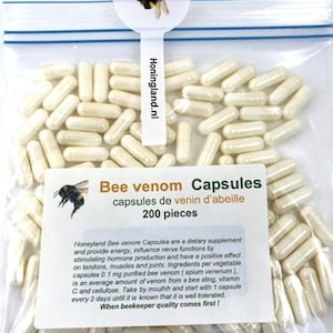 Pode incluir: Um saco de plástico transparente e selável contendo 200 cápsulas de cor esbranquiçada. O rótulo apresenta um gráfico de abelha, o texto "Bee venom Capsules" e informações do produto. Uma aba no topo exibe o texto "Honingland.nl".