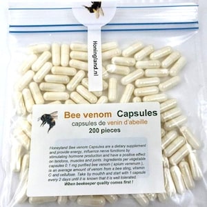 Pode incluir: Um saco de plástico transparente e selável contendo 200 cápsulas de cor esbranquiçada. Um rótulo branco na frente apresenta um gráfico de abelha, o texto "Bee venom Capsules" e informações detalhadas. Uma aba no topo exibe "Honingland.nl".