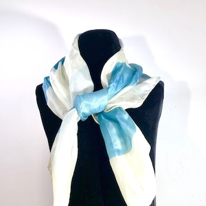 A whisper soft very delicate silk scarf with wide bands of light and lighter turquoise and pale ivory.