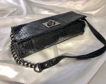 Kenneth Cole Reaction - A soft black fabric "faux snakeskin" shoulder bag with pewter toned metal details including the unique turning clasp