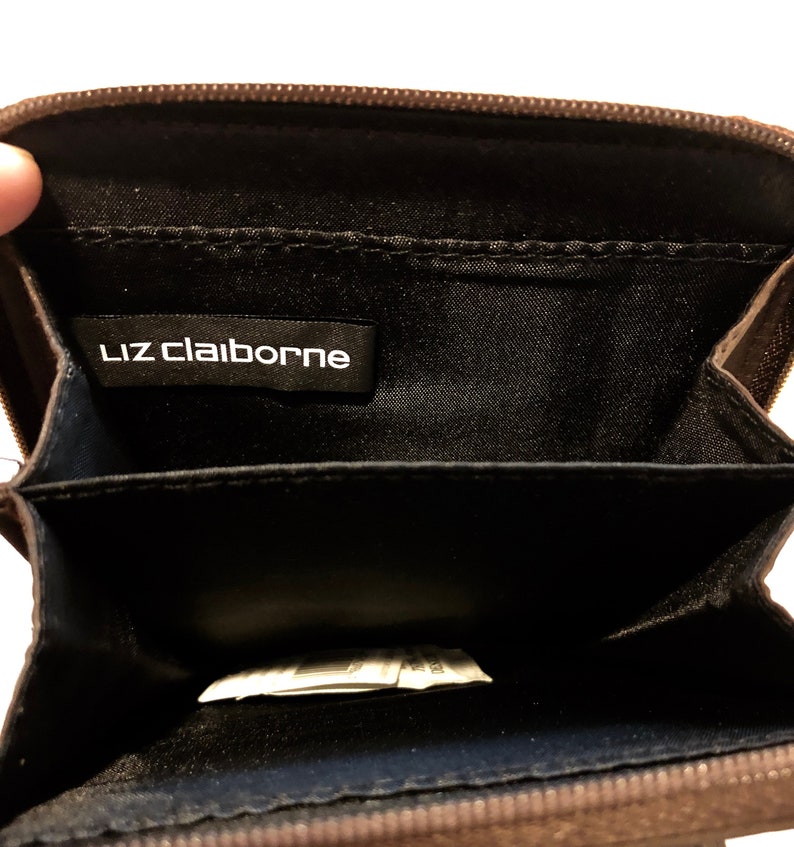 A soft buttery chocolate brown leatherette foldover clutchwallet with snap closure tucked beneath for a clean sleek look. Liz Claiborne