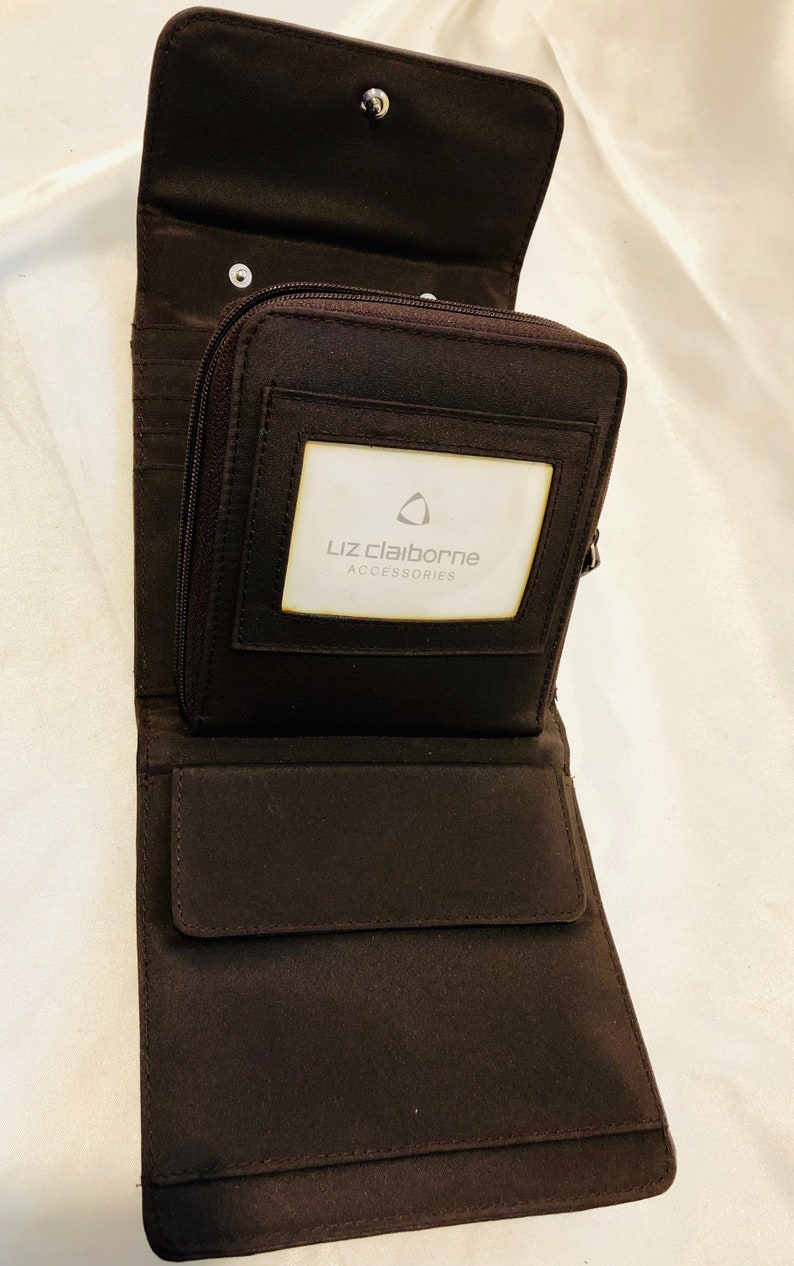 A soft buttery chocolate brown leatherette foldover clutchwallet with snap closure tucked beneath for a clean sleek look. Liz Claiborne
