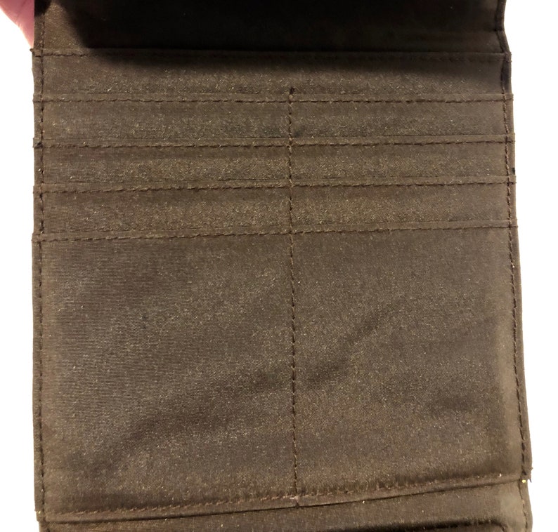 A soft buttery chocolate brown leatherette foldover clutchwallet with snap closure tucked beneath for a clean sleek look. Liz Claiborne