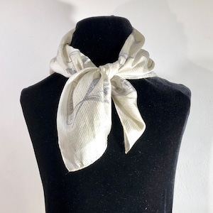 Jones  New York  - A delicately textured ivory &quot; necktie&quot; scarf with a pattern of floating lovely silvery grey flowers
