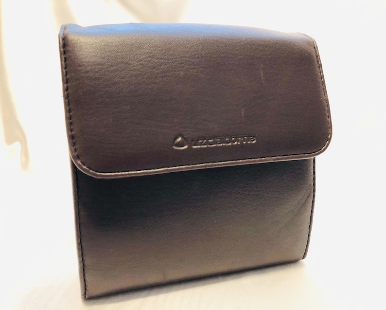A soft buttery chocolate brown leatherette foldover clutchwallet with snap closure tucked beneath for a clean sleek look. Liz Claiborne